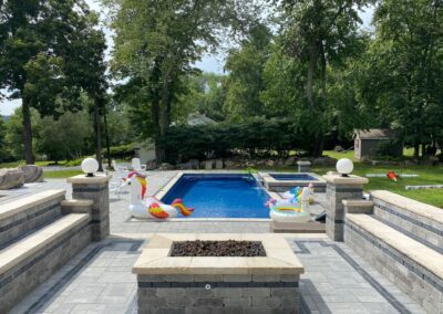 A backyard oasis featuring a pool and fire pit, perfect for relaxing and entertaining guests.